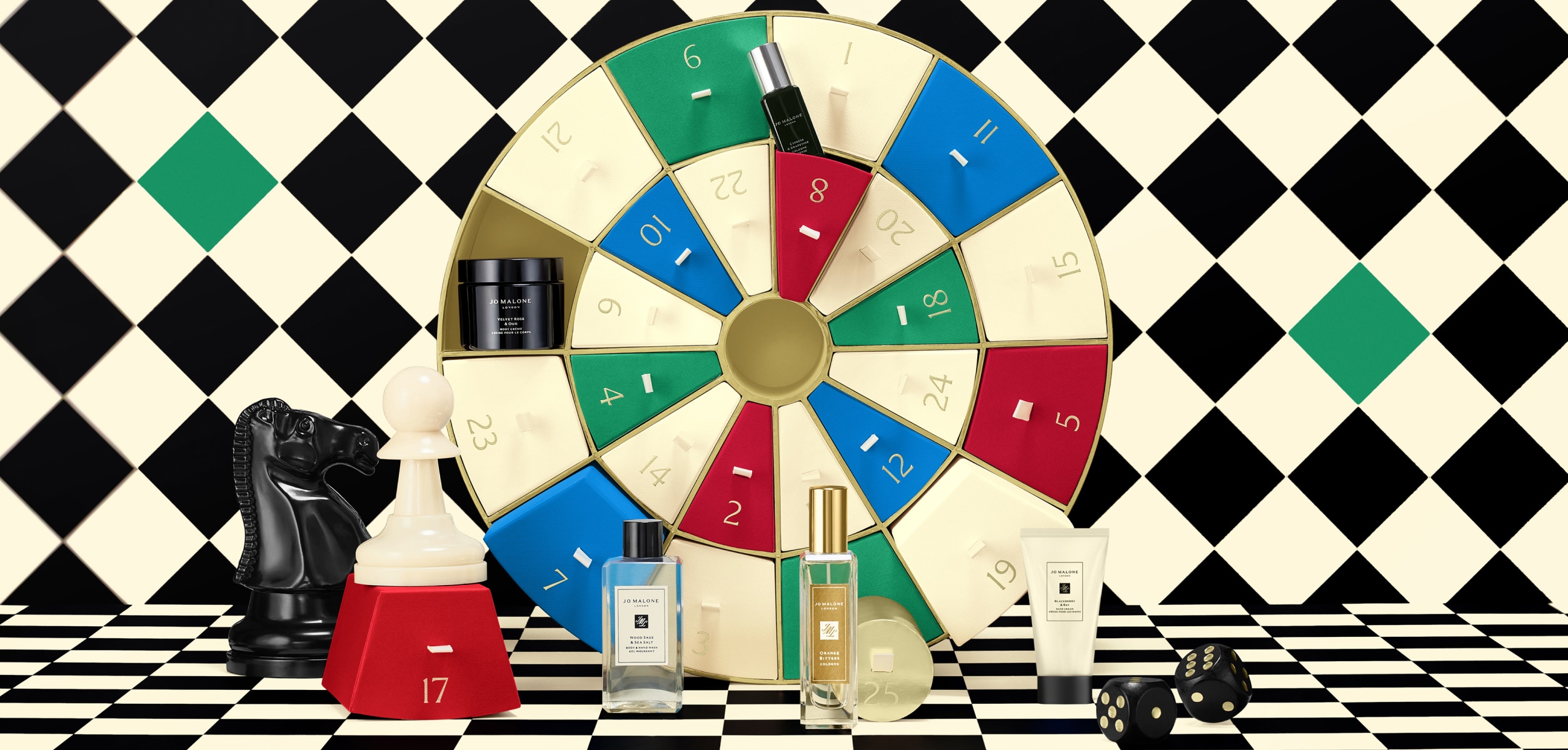 Launch image of advent calendar dartboard box shown open with examples of 5 product contents on checkerboard background.